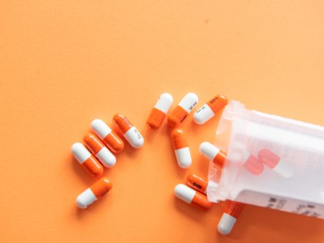pill bottle with orange background.