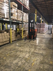 A warehouse with boxes and forklift.
